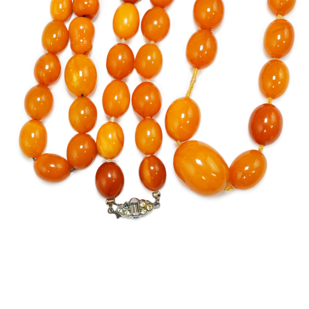 Two single strand graduated oval amber bead necklaces, longest 70cm, and a small group of amber beads strung as a bracelet